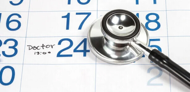 A stethoscope lying on a calendar, symbolizing medical scheduling